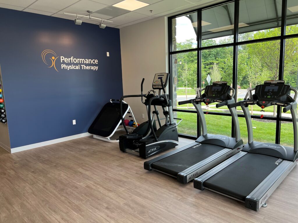 equipments in a gym and a logo of Performance Physical Therapy Logo.