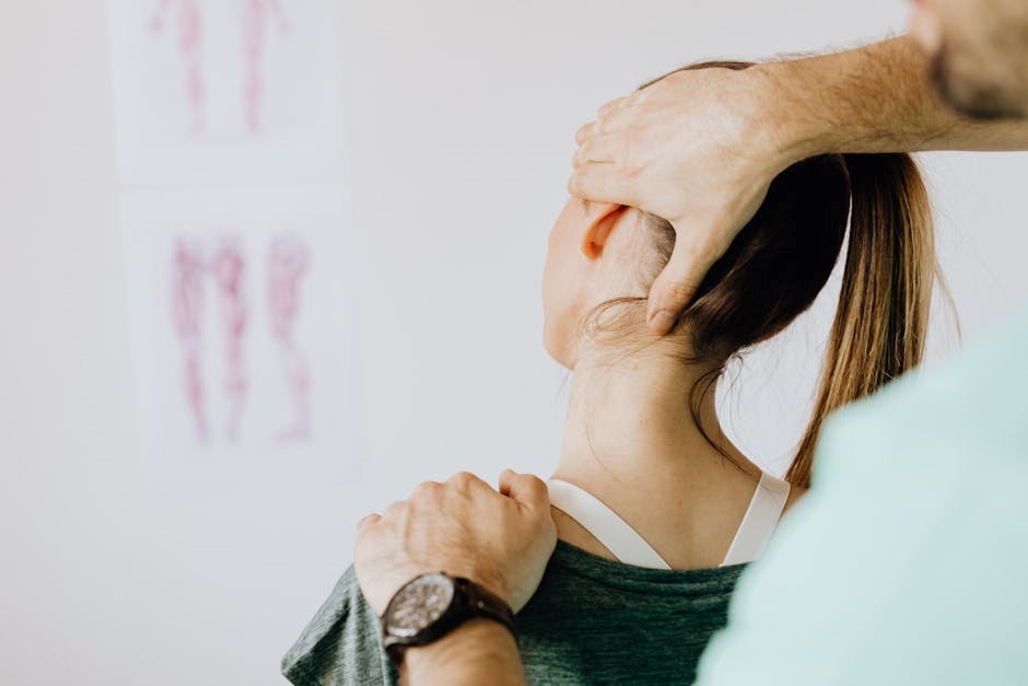 A chiropractor adjusting a female patient's neck in a clinic, with anatomical posters visible in the background.