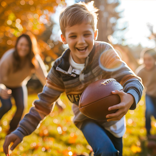 kid running with a football among the falling leaves