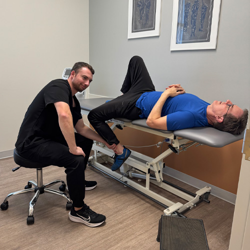 physical therapist at Performance Physical Therapy checking his patient's mobility during an appointment